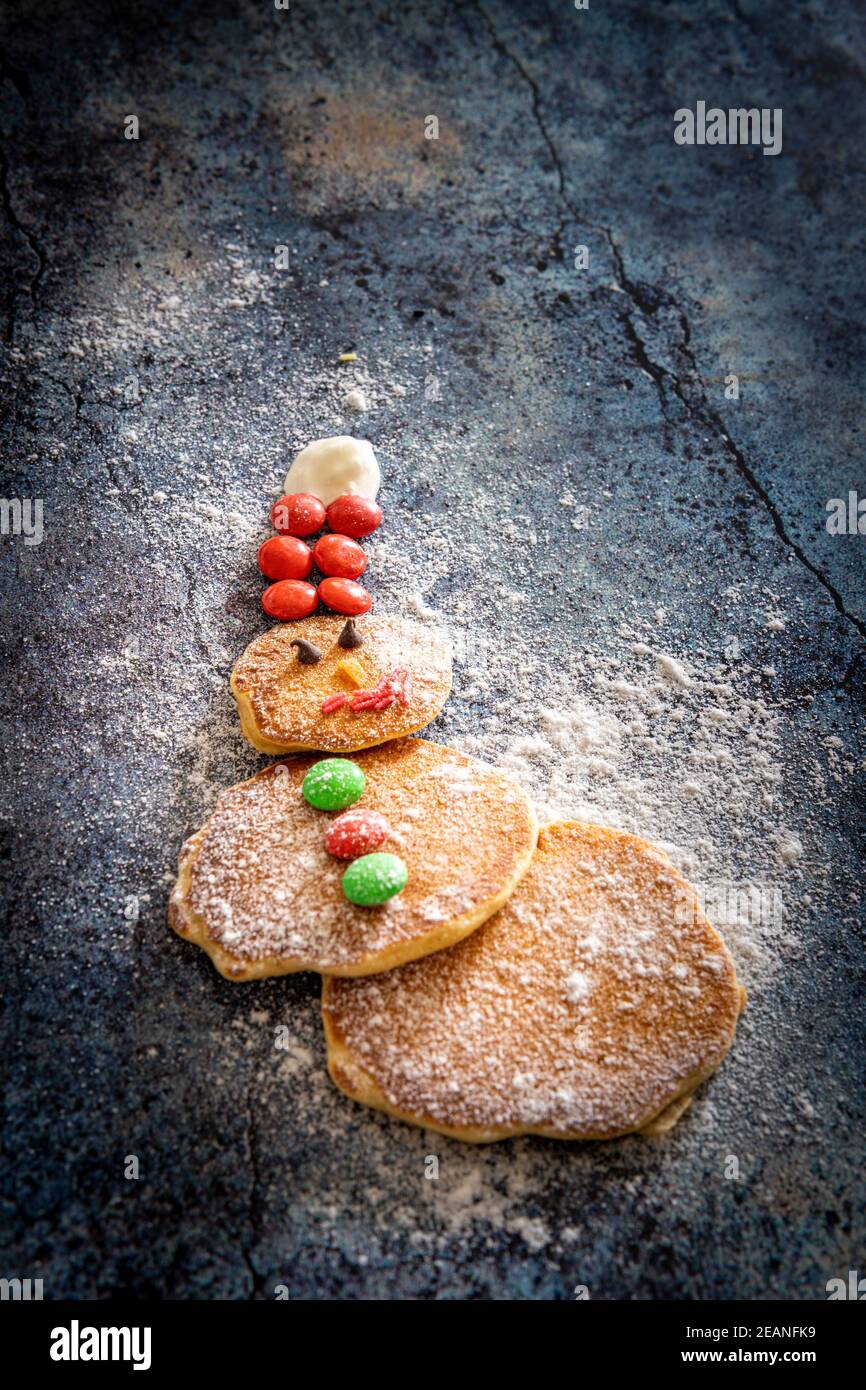 Hausgemachte Pfannkuchen in Form von Schneemann mit Zucker Knöpfe auf dem Tisch Hintergrund zu Weihnachten, Italien, Europa dekoriert Stockfoto