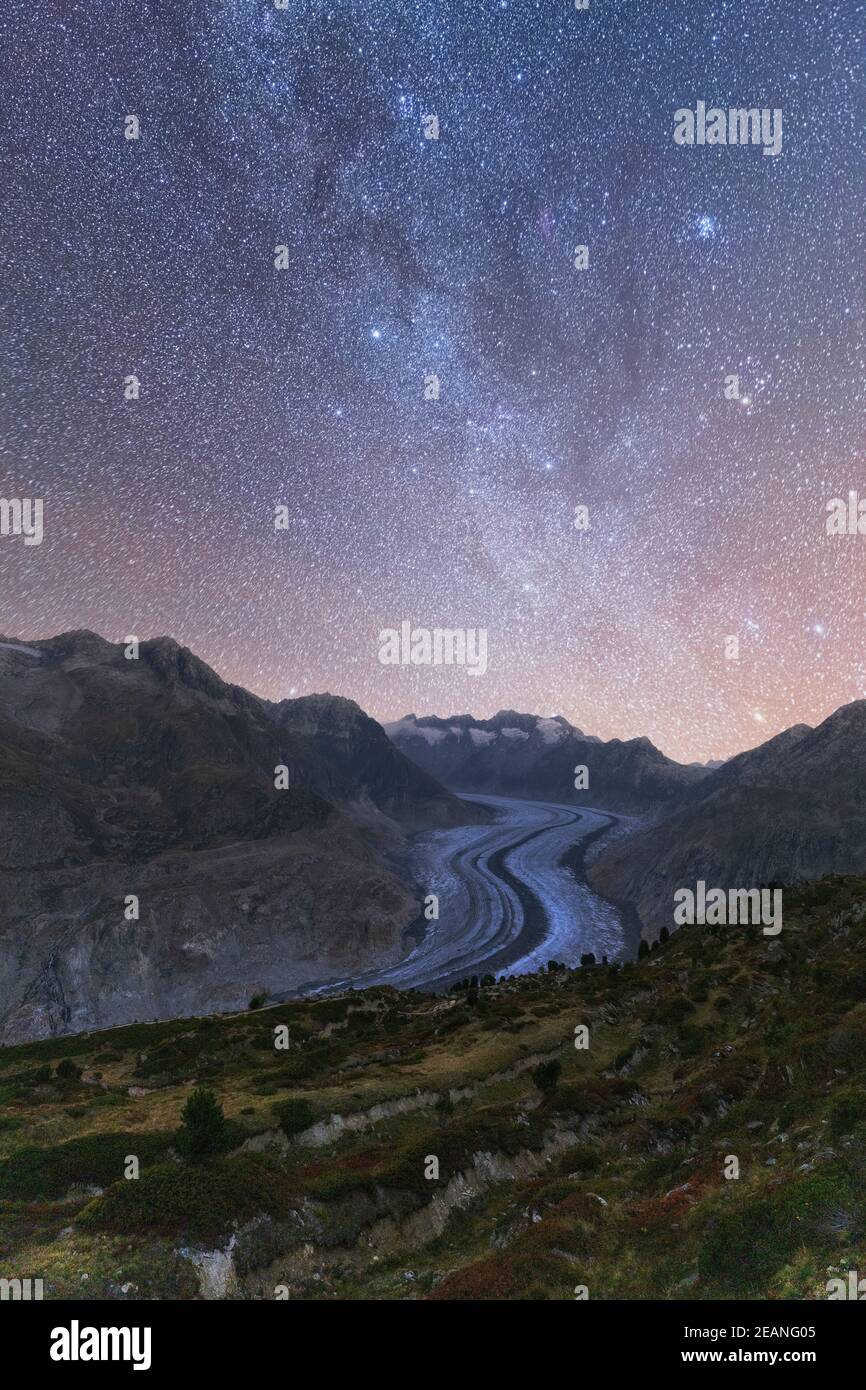 Leuchtende Sterne und Milchstraße am Nachthimmel über dem Aletschgletscher, den Berner Alpen, dem Kanton Wallis, der Schweiz, Europa Stockfoto