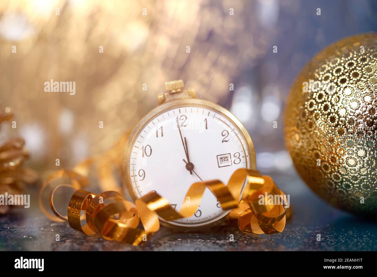 Neujahr um Mitternacht - Alte Uhr mit Weihnachtsdekoration, Champagner und Weihnachtsbeleuchtung Stockfoto