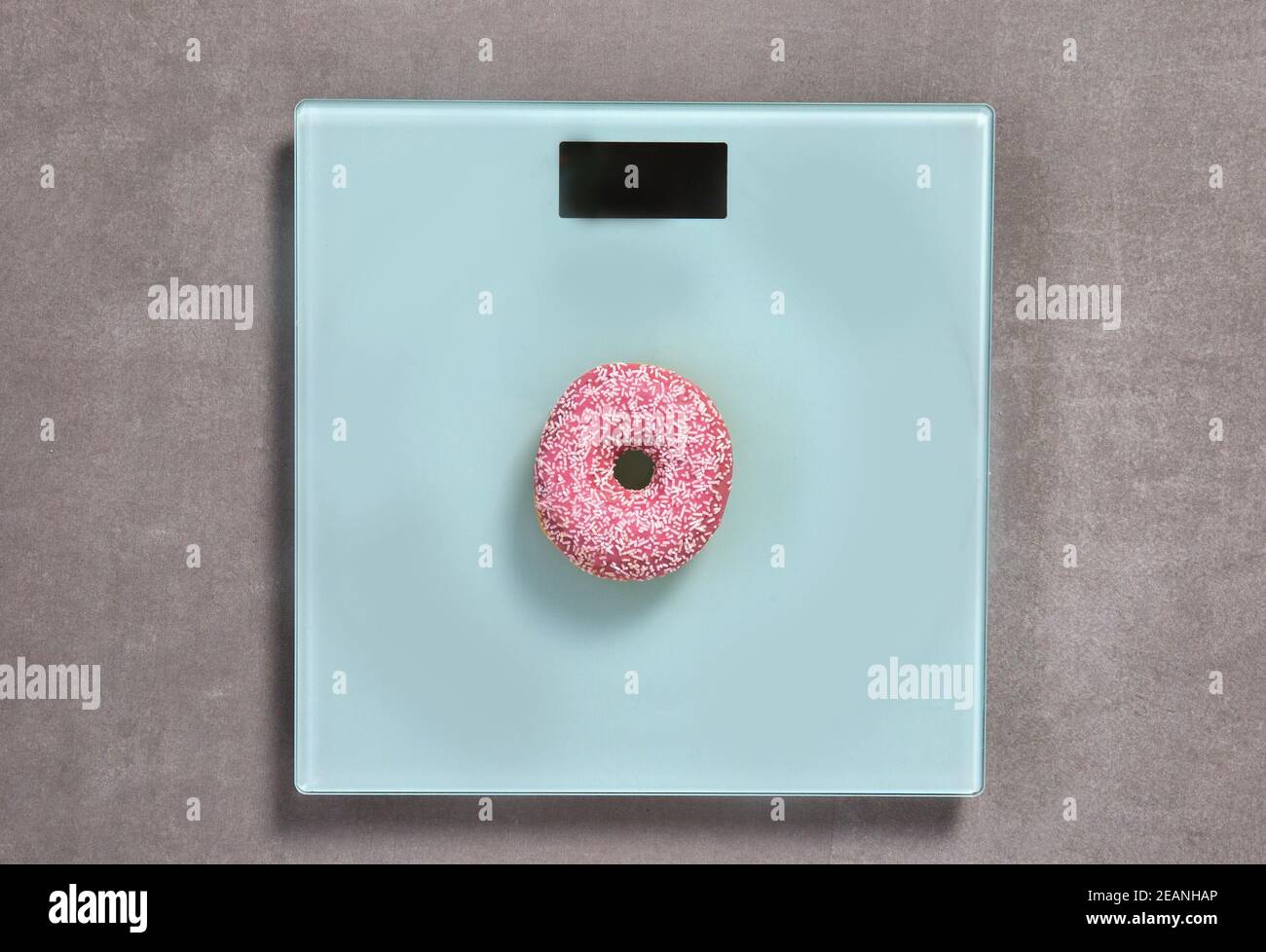 Waage mit süßen rosa glasierten Donut mit Streuseln Draufsicht, kopieren Raum für Text oder Design, Zucker, Junk-Food-Konzept Hintergrund Stockfoto