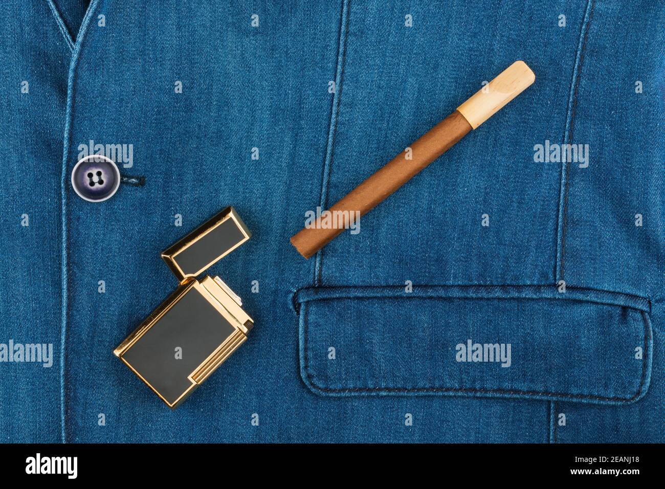 Zigarre und Feuerzeug liegen auf einer blauen Denim-Jacke Stockfoto