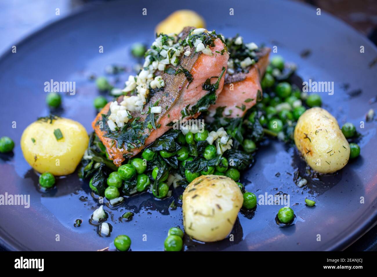 Lachsfilet mit grünen Erbsen und Spinat Stockfoto