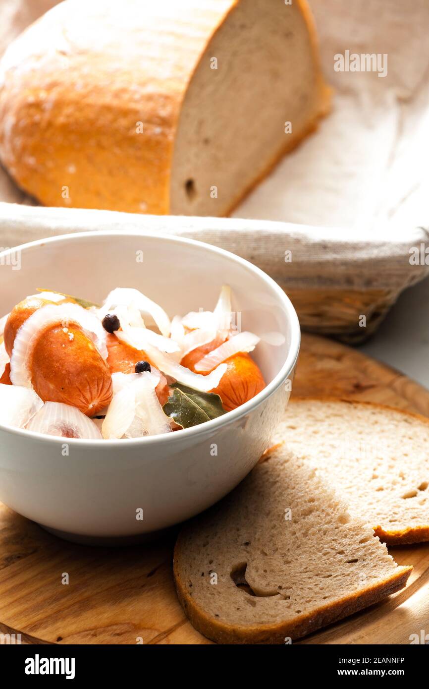 Hausgemachte eingelegte Würstchen mit Zwiebeln und Brot Stockfoto