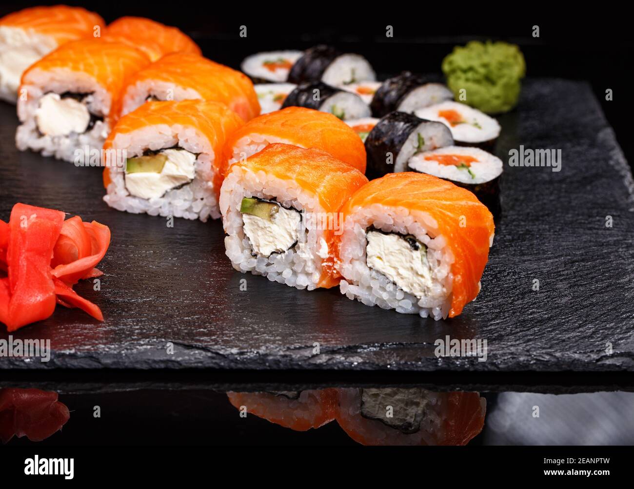 Zwei verschiedene Arten von Sushi-Rollen auf einem Steinbrett. Japanische Küche. Stockfoto