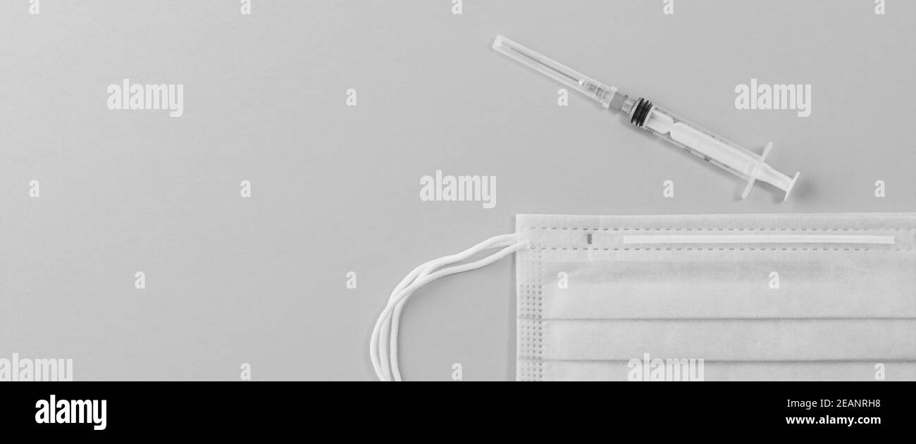 Medizinische Maske chirurgische Schutzvirus, Grippe, Krankheit, Pillen und Spritze. Isoliert auf einem rosa Hintergrund. Stockfoto