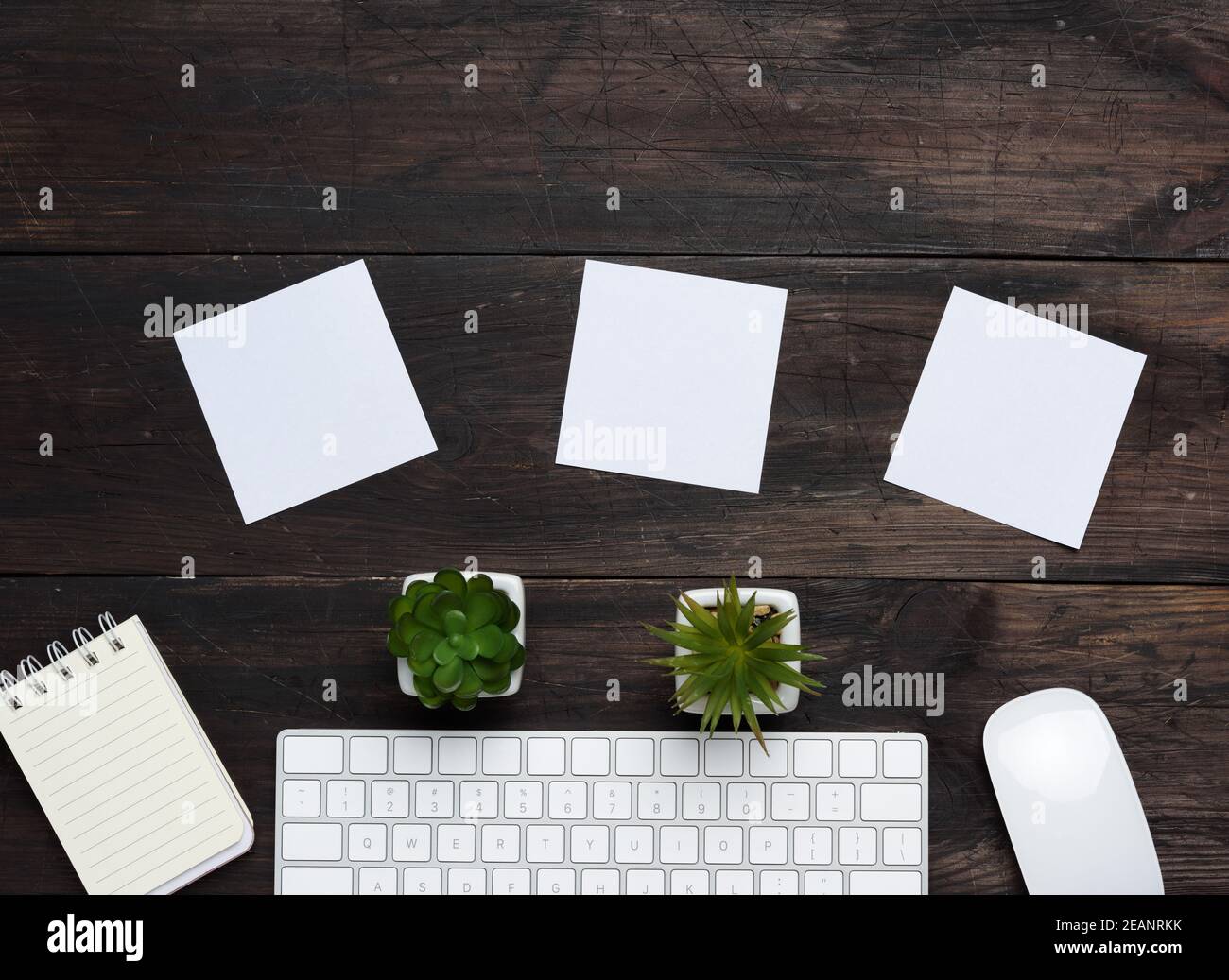 Weiße kabellose Tastatur und Maus auf einem braunen Holztisch Stockfoto