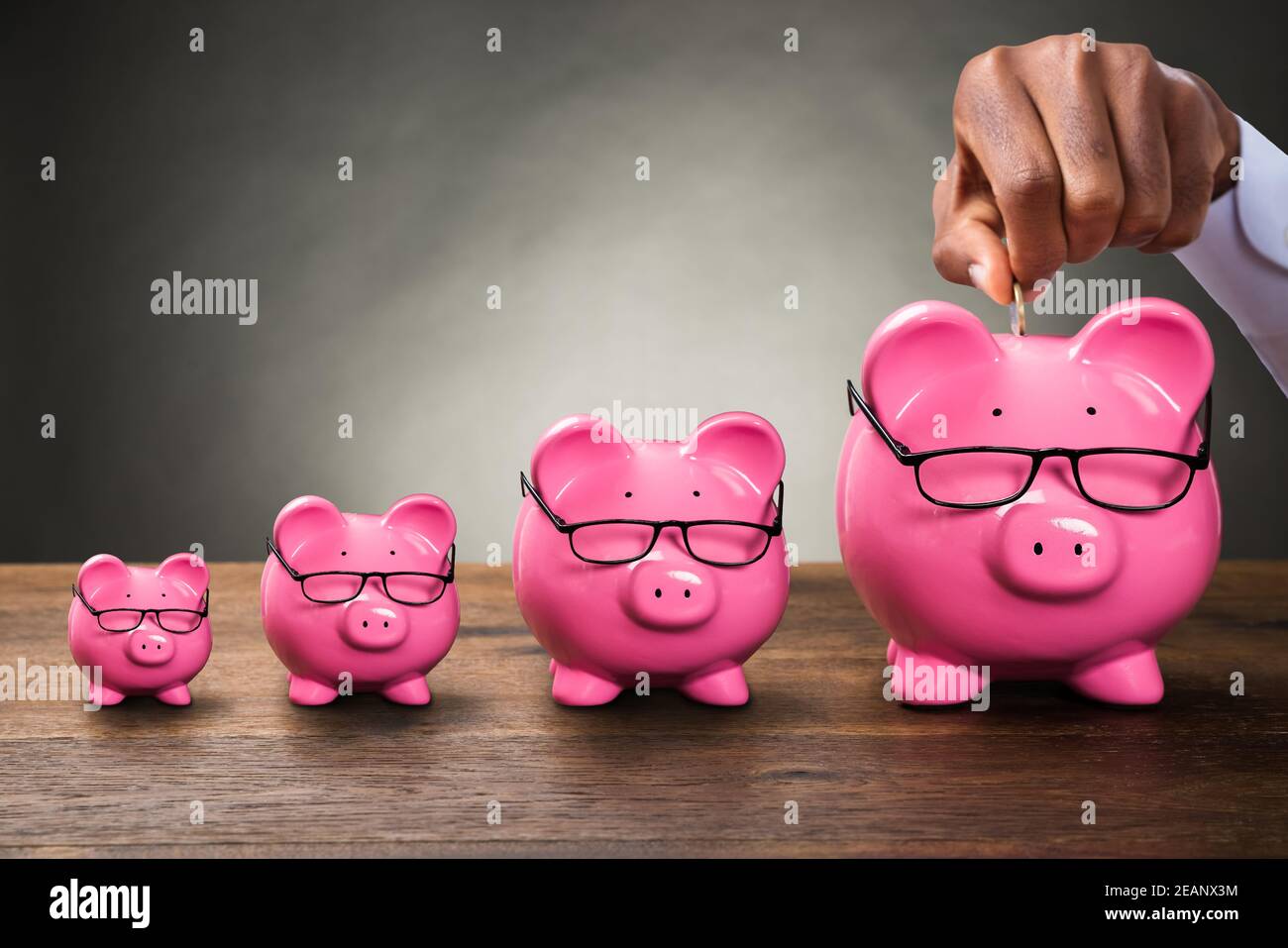 Person Hand Inserting Münze In Sparschwein Stockfoto Person Hand Inserting Münze In Sparschwein Stockfoto