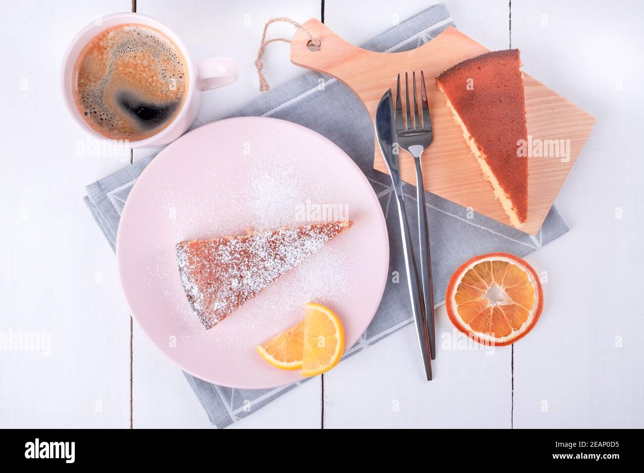 Zwei Stück Kuchen auf einem rosa Teller und ein Schneidebrett Stockfoto