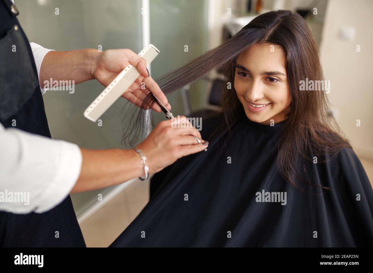 Friseur mit Schere schneidet Frauenhaare Stockfoto