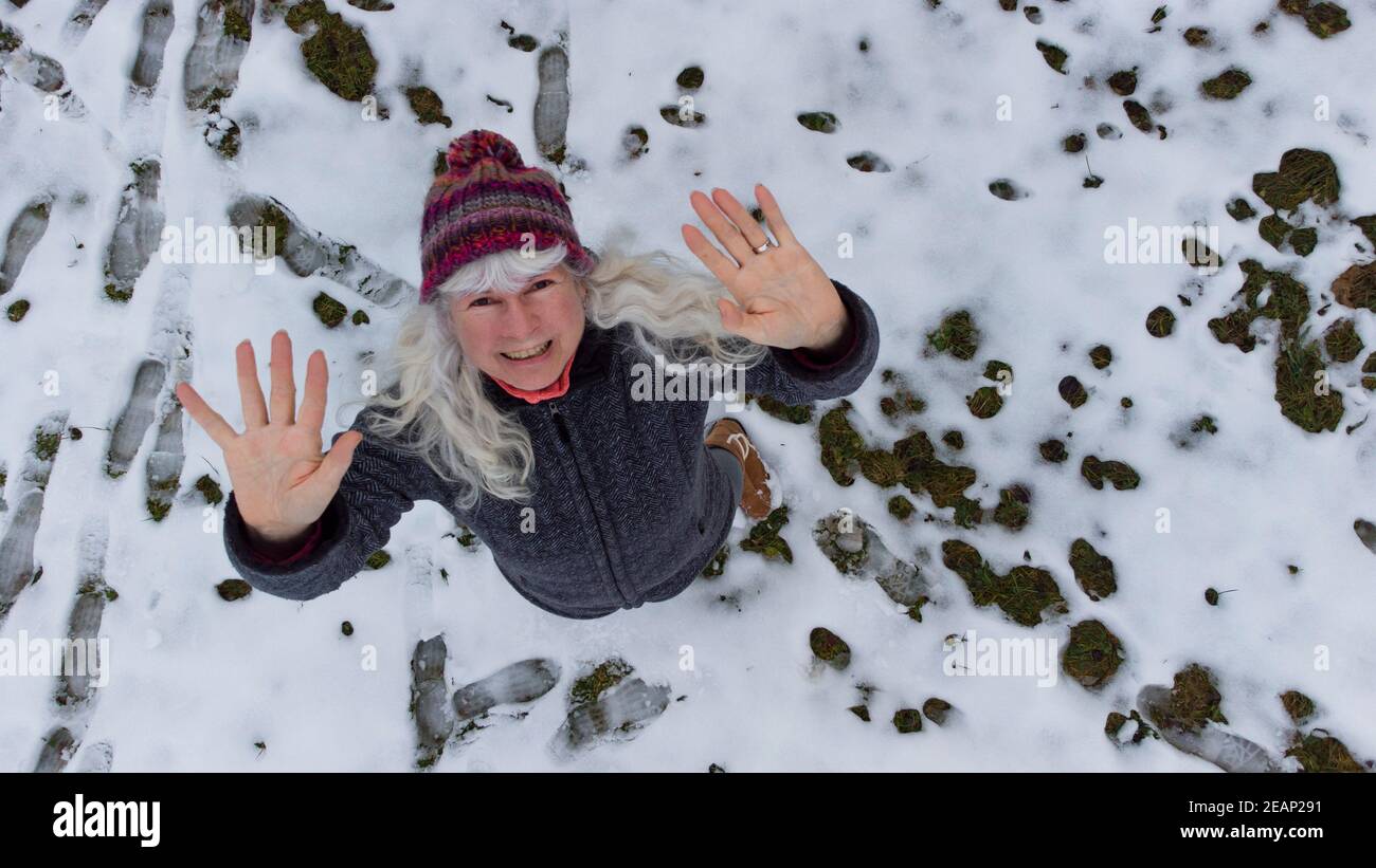 Mit einer Drohne erschossen. Eine Frau winkt in Richtung Himmel Stockfoto