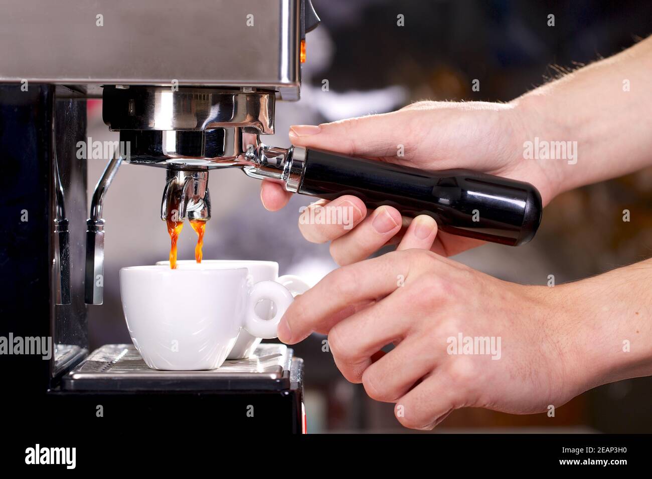 Nahaufnahme der Espressomaschine, die zwei Tassen füllt Stockfoto