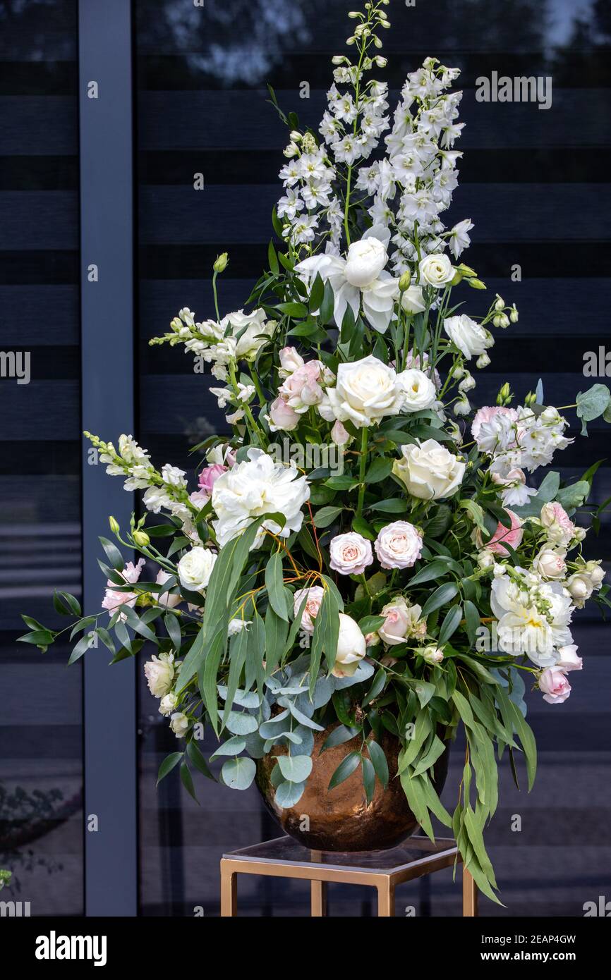 Beeindruckendes floristisches Bouquet von weißen Rosen und Delphinium - grün Drehen Stockfoto