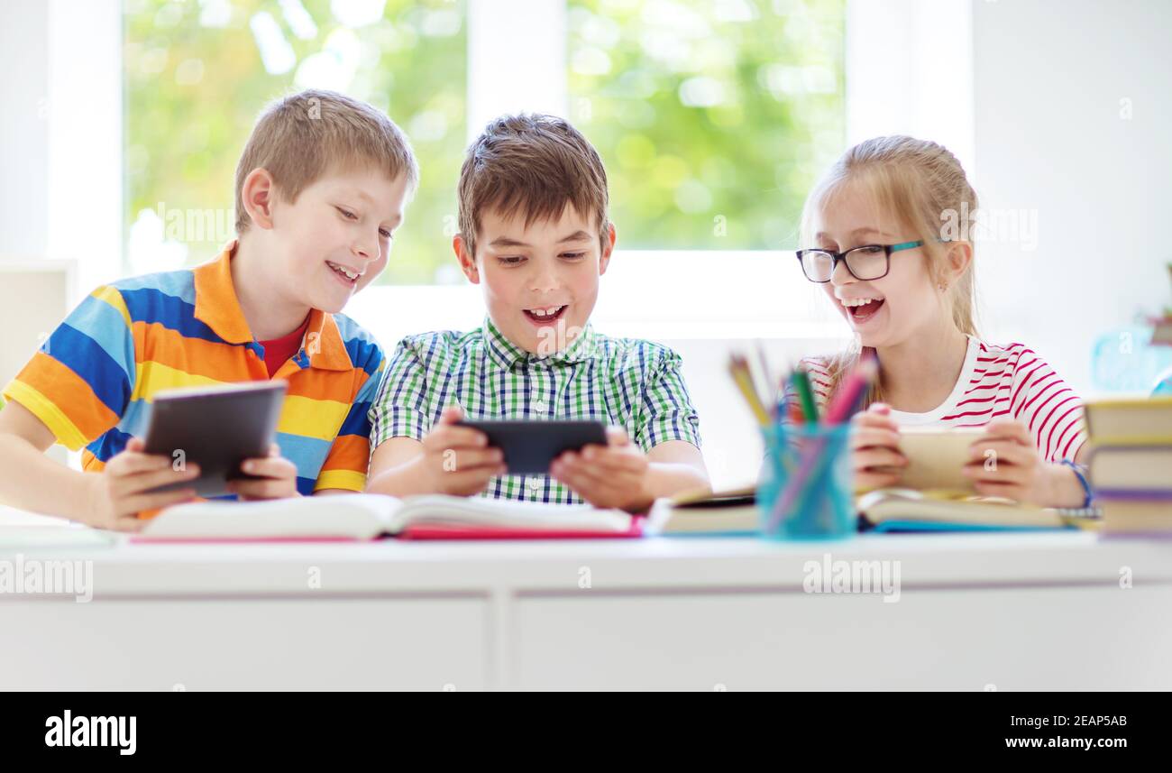 Kinder im Zimmer mit Smart Phones Stockfoto