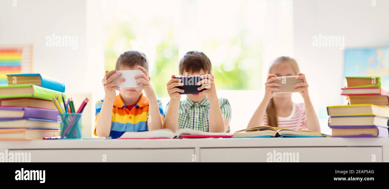 Kinder im Zimmer mit Smart Phones Stockfoto