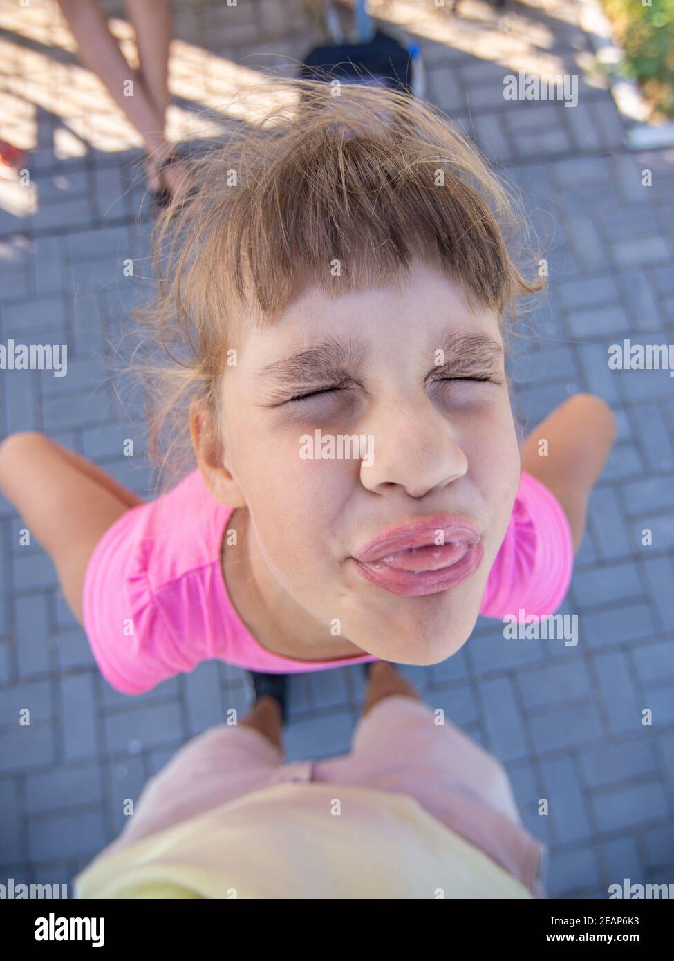 Schelmische Mädchen grimaces und zeigt eine abscheuliche Schnauze mit einem Zunge Stockfoto