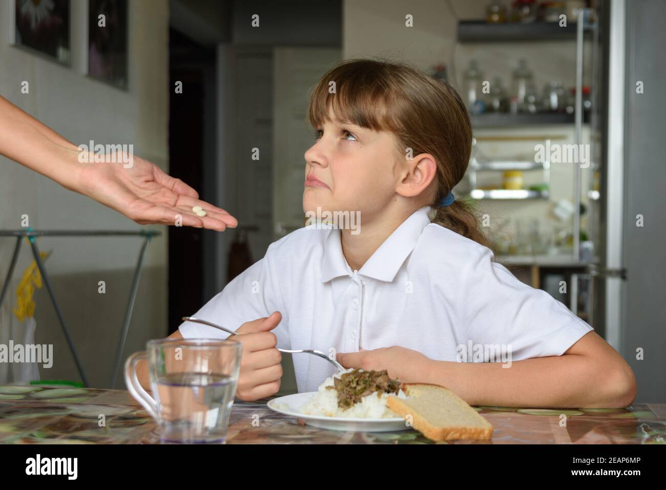 Mädchen weigert sich, Medizin vor dem Abendessen zu nehmen Stockfoto