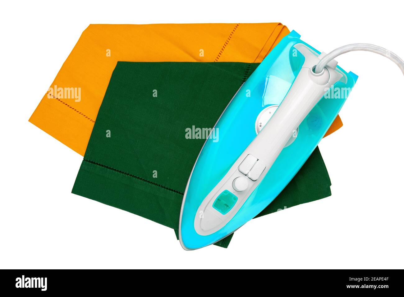 Draufsicht auf ein modernes elektrisches blaues Bügeleisen Bügeln einer grünen und einer gelben Stoffserviette isoliert auf weißem Hintergrund. Hausarbeit Konzept. Stockfoto