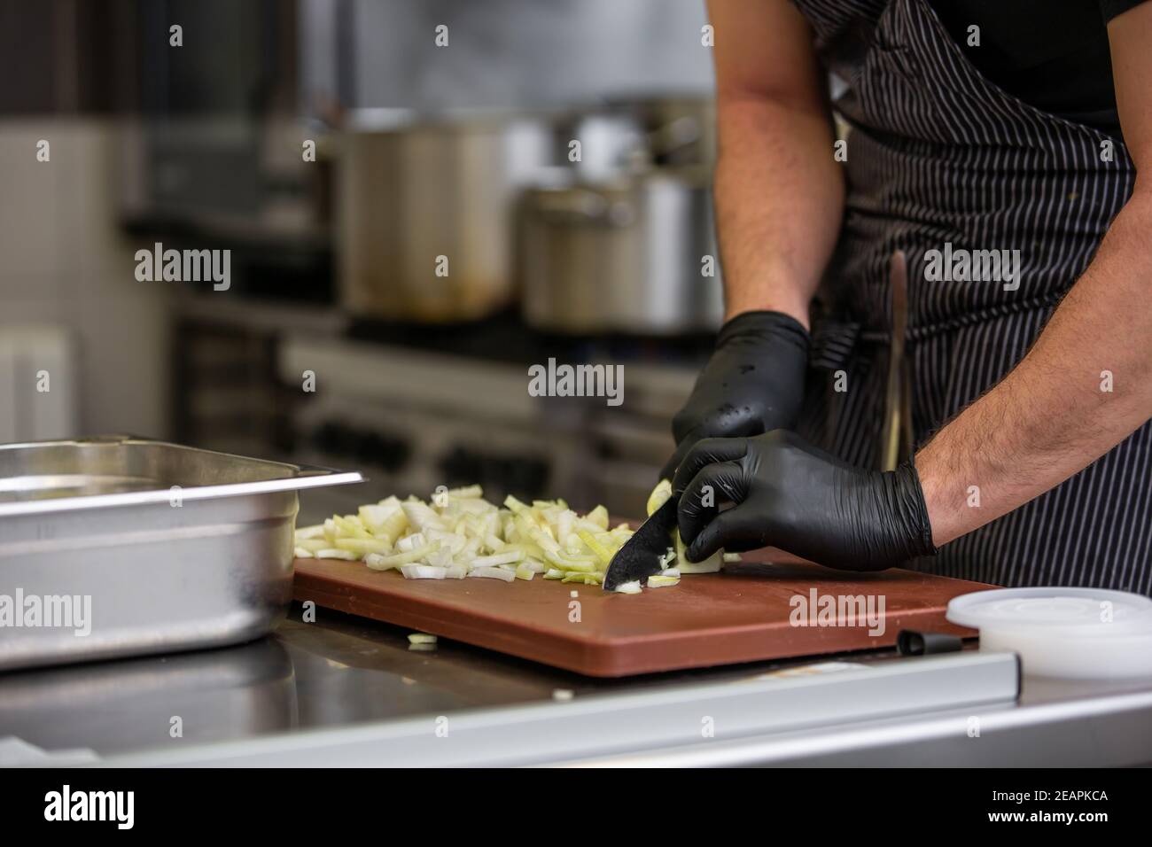 Koch schneiden Zwiebeln in der Küche in einem Restaurant, Zubereitung von Speisen Konzept Stockfoto