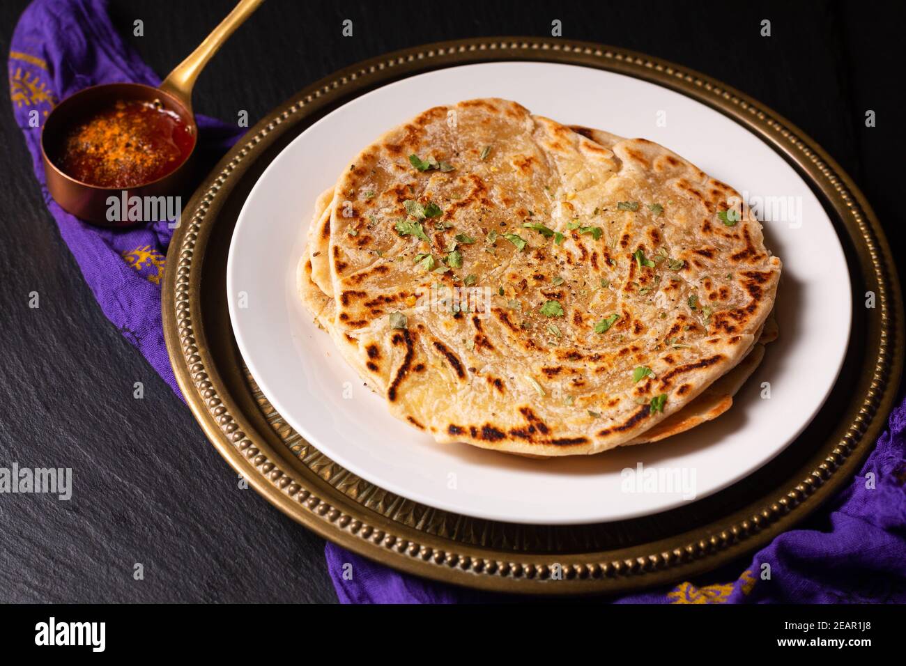 Food Konzept Spot Fokus hausgemachte Paratha, Parotta oder Porotta geschichteten Fladenbrot auf schwarzem Hintergrund mit Kopierraum Stockfoto