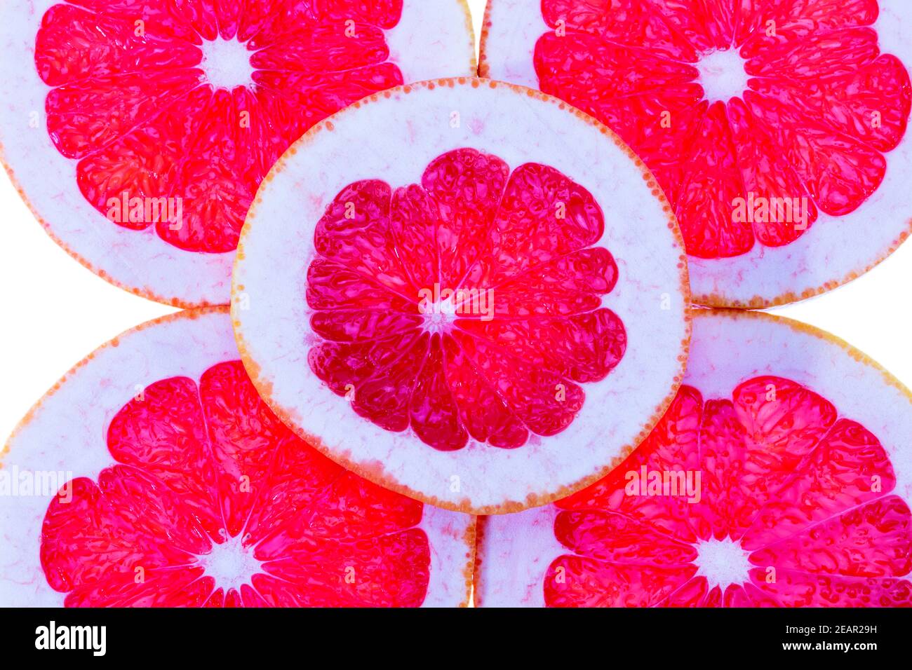 Zusammensetzung von Scheiben von Zitrusfrüchten der roten Grapefruit auf weißem Hintergrund, Nahaufnahme Stockfoto