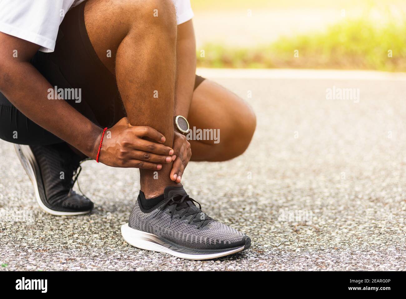 Sport Läufer Mann verwenden Hände Gelenk halten Beinschmerzen, weil Verdrehter Knöchel beim Laufen gebrochen Stockfoto
