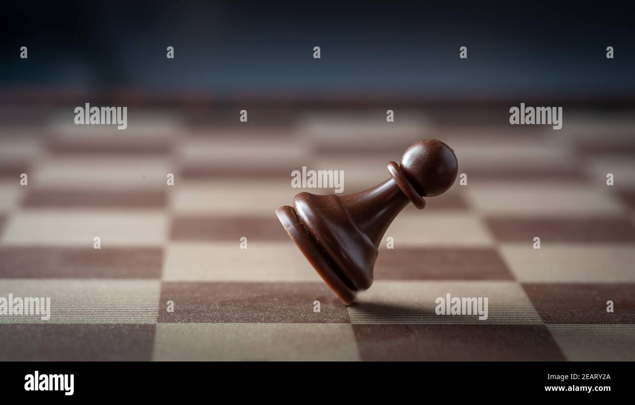 Schwarze Schachfigur fällt auf Schachbrett Konzept des Scheiterns. Stockfoto