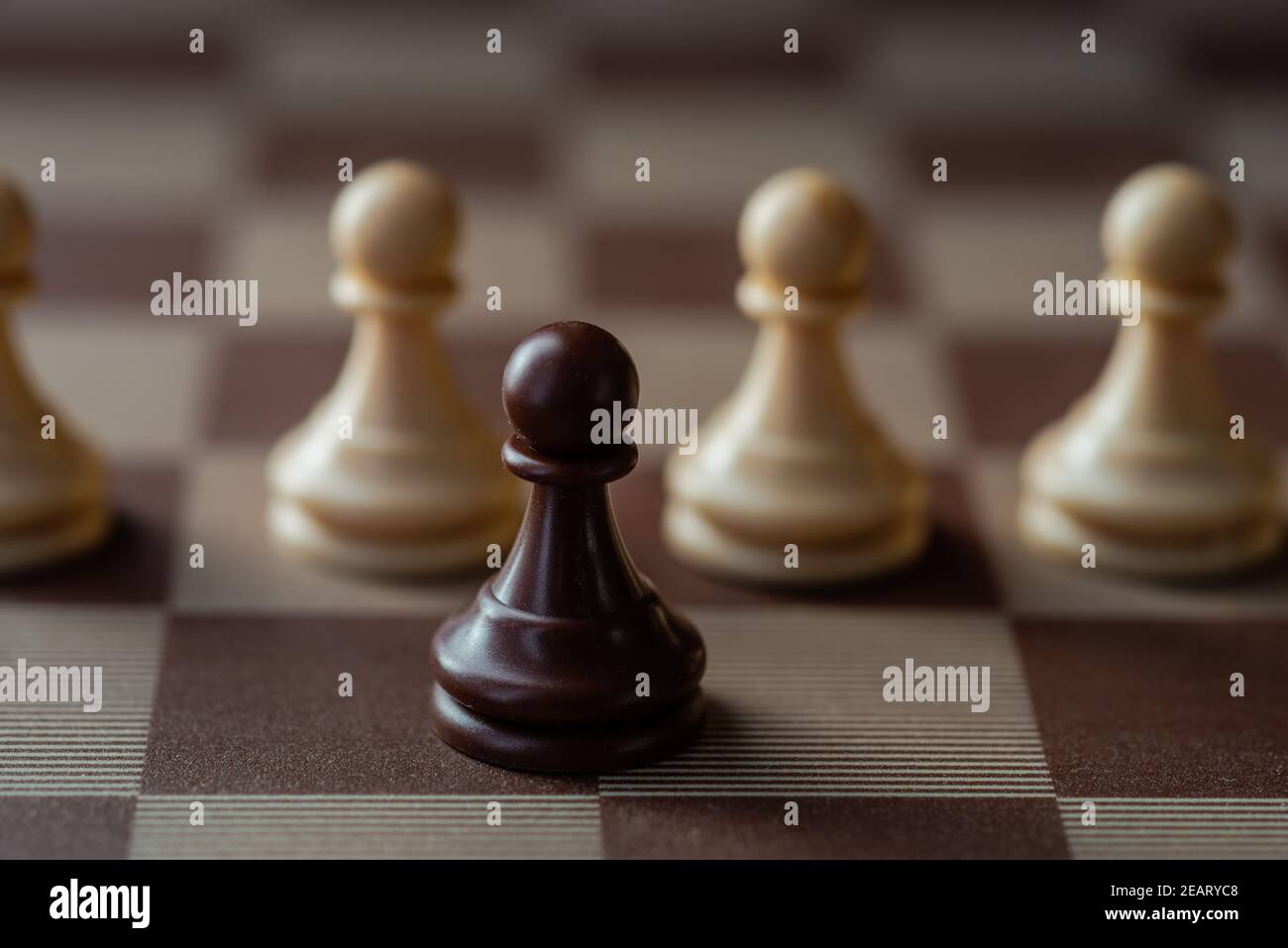 Schwarze Schachfigur vor weißen Bauern, Konzept anders oder aufstehend. Stockfoto