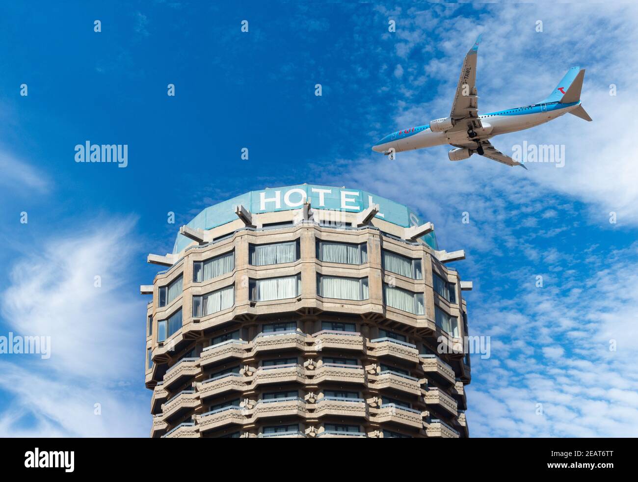 Zusammengesetztes Bild eines TUI-Flugzeugs, das über das Hotel fliegt. Quarantäne-Hotel, Coronavirus, Covid-Konzept. Stockfoto