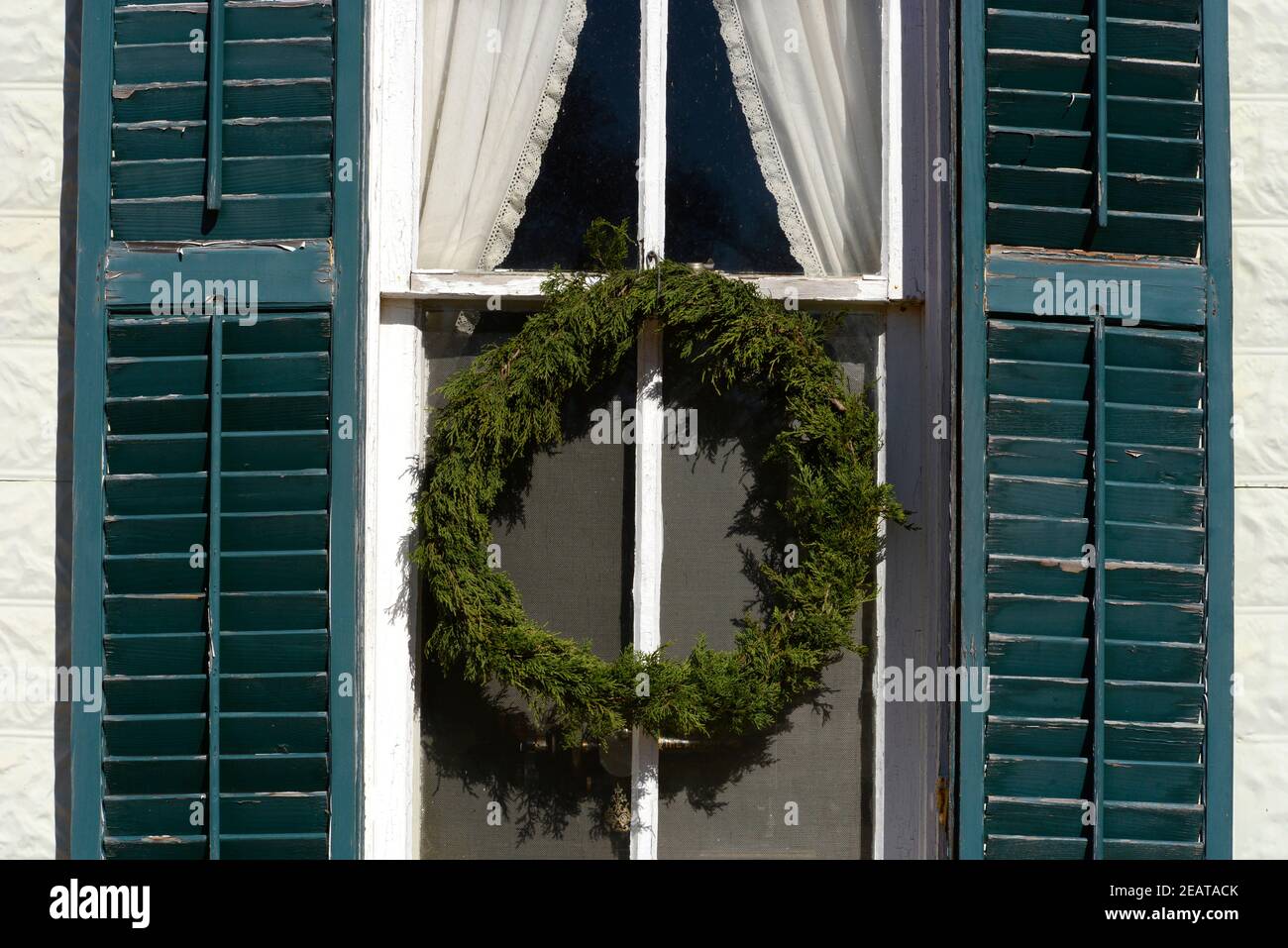 Ein altmodischer handgefertigter Weihnachtskranz hängt an einem historischen Haus auf der Sauer Beckmann Living History Farm in Stonewall, Texas. Stockfoto