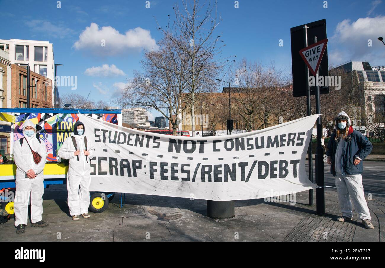 Student Rent Strike, Lower Marsh Street, London, Großbritannien 10th. Februar 2021. Schüler in Hazmat Anzüge und Masken halten Banner, die besagt, dass die sind "tudents nicht Verbraucher". Sie protestieren gegen hohe Mieten und Gebühren zu zahlen, während sie wenig in der Art der Ausbildung oder Unterkunft wegen der laufenden Covid 19 Pandemie Kredit erhalten: Denise Laura Baker/Alamy Live News Stockfoto