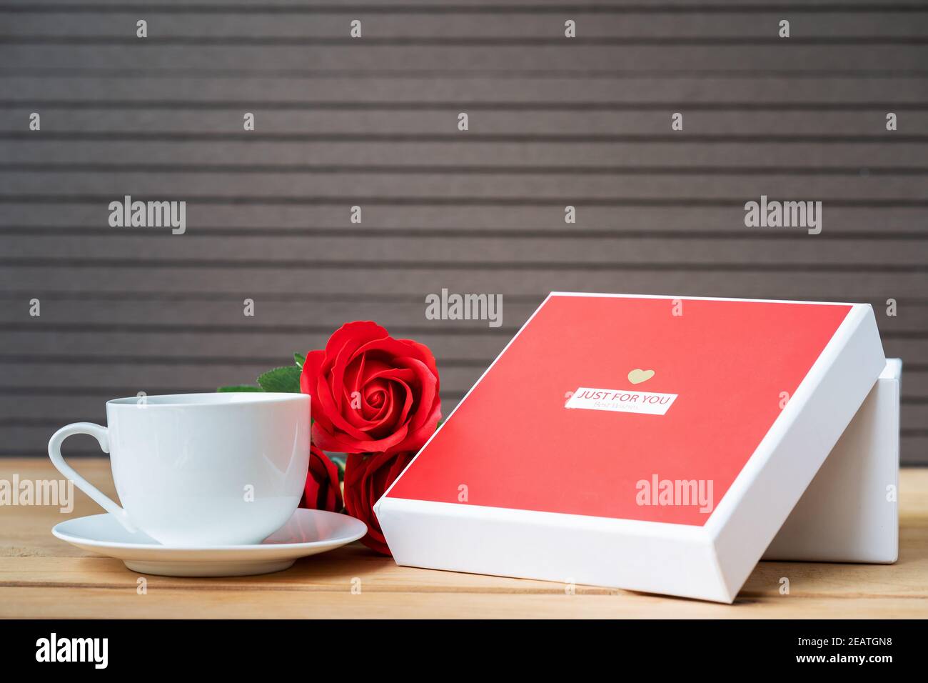 Rote Rosen und Geschenkbox auf Holz Hintergrund Stockfoto