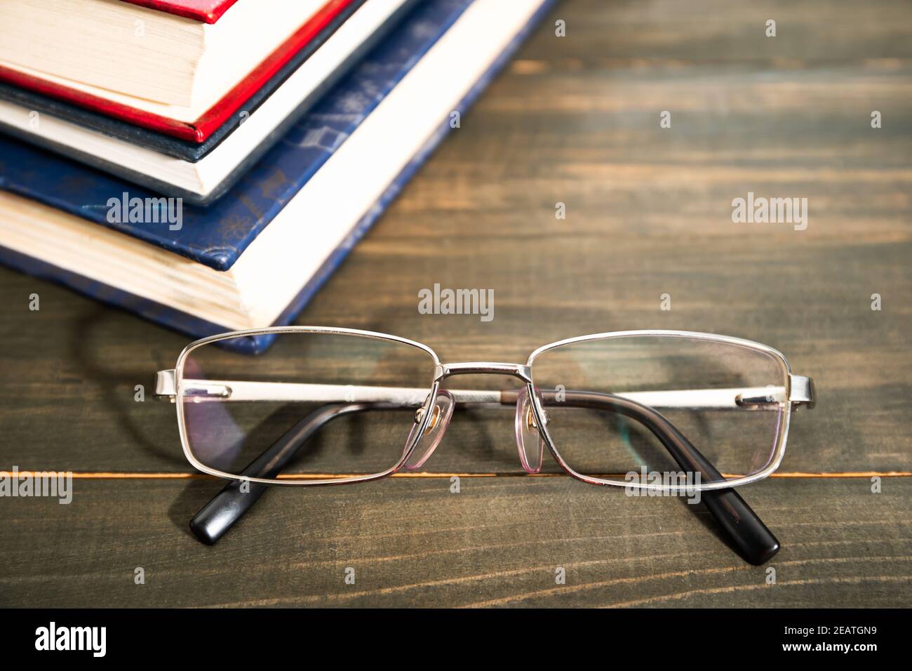 Gläser und Stapel von Hardcover-Büchern Stockfoto