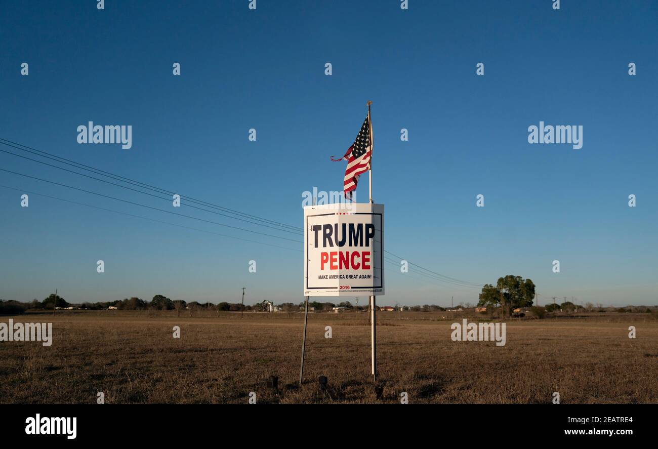 Ein Landwirt außerhalb von Smithville im Bastrop County, TX, fliegt drei Monate nach der Novemberwahl, bei der die republikanische Karte verloren hat, eine leicht zerfetzte amerikanische Flagge über einem Trump-Pence-Wahlkampfschild. Meinungsumfragen zeigen, dass sich viele Texaner im ländlichen Raum immer noch weigern, einen demokratischen Präsidentschaftssieg zu akzeptieren. ©Bob Daemmrich Stockfoto