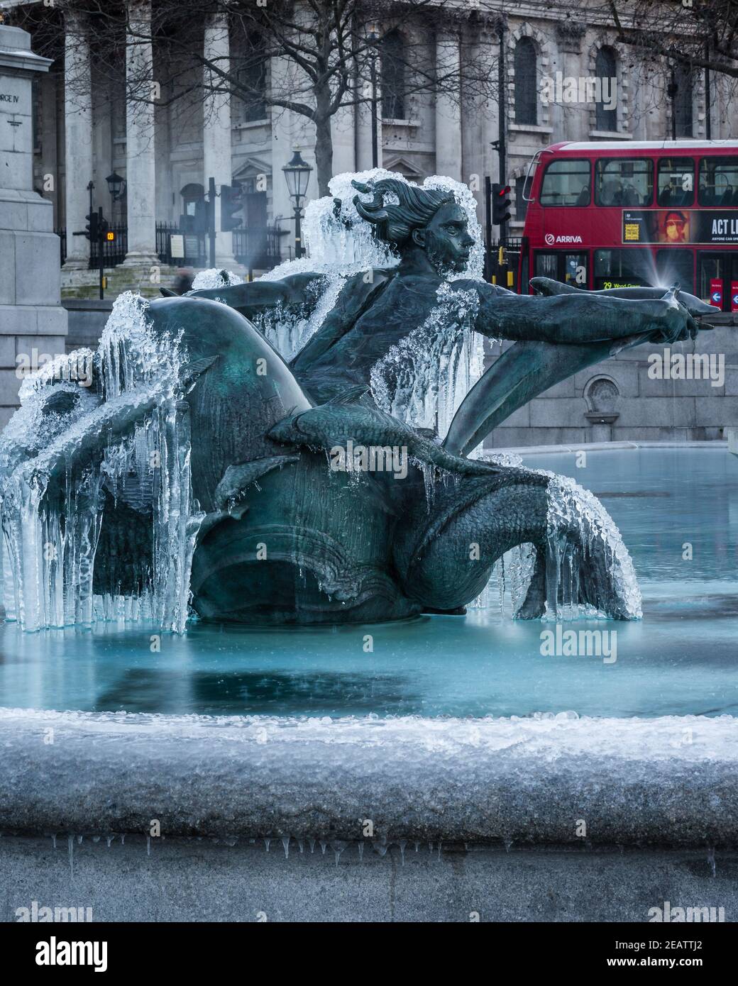 Ein roter Doppeldeckerbus fährt vorbei, als Storm Darcy "The Beast from the East II" zum Trafalgar Square in London bringt und die Brunnen einfriert. Stockfoto