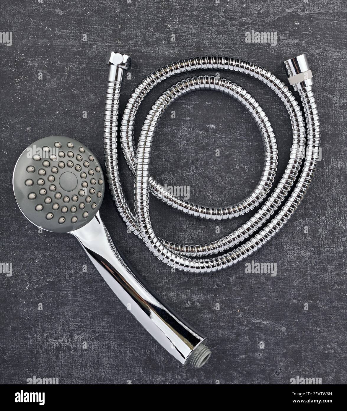Draufsicht, Duschkopf und flexibler Verbindungsschlauch Nahaufnahme auf grauem schäbigen Hintergrund Stockfoto