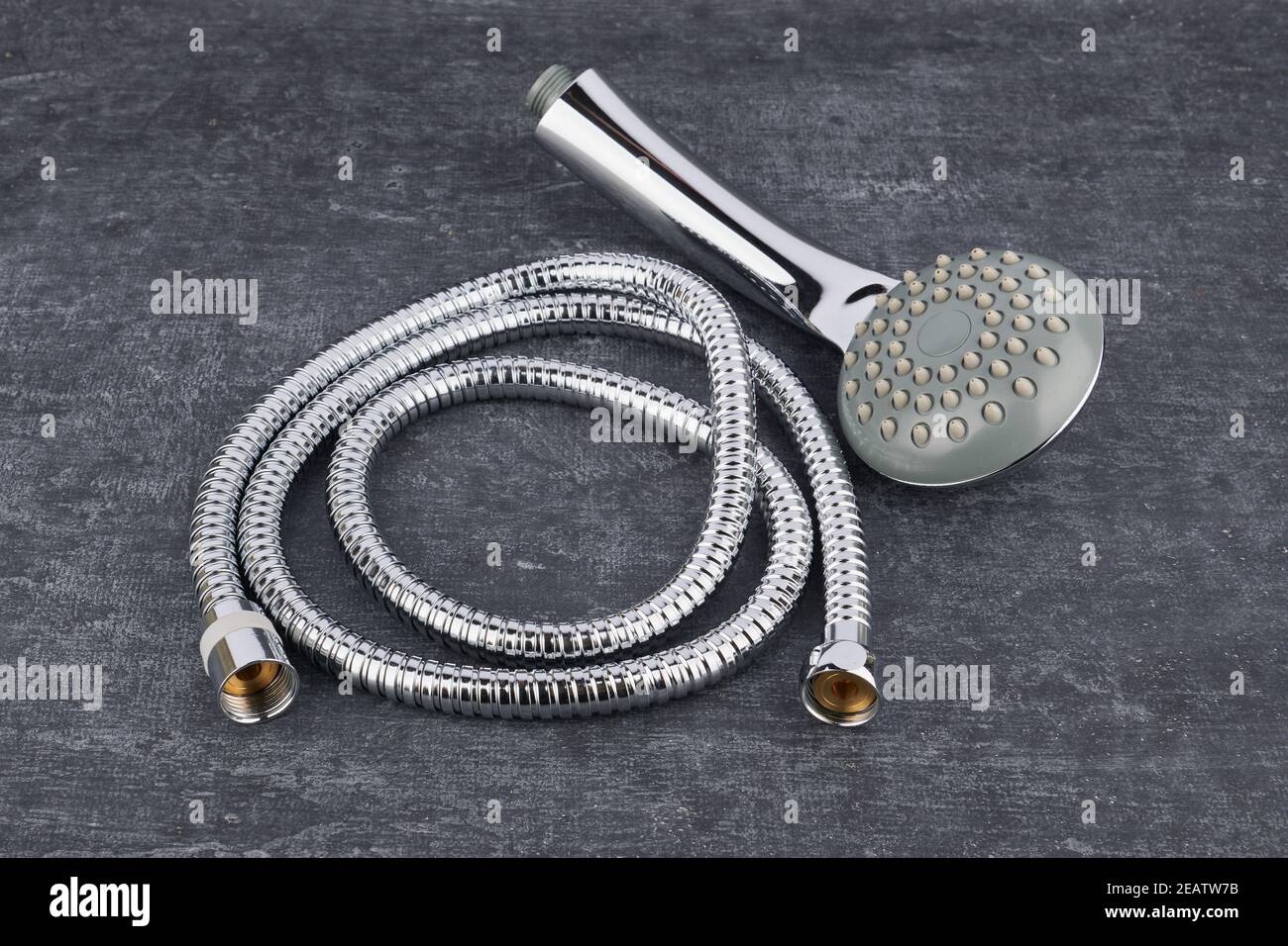 Duschkopf und flexibler Verbindungsschlauch Nahaufnahme auf grauem schäbigen Hintergrund Stockfoto