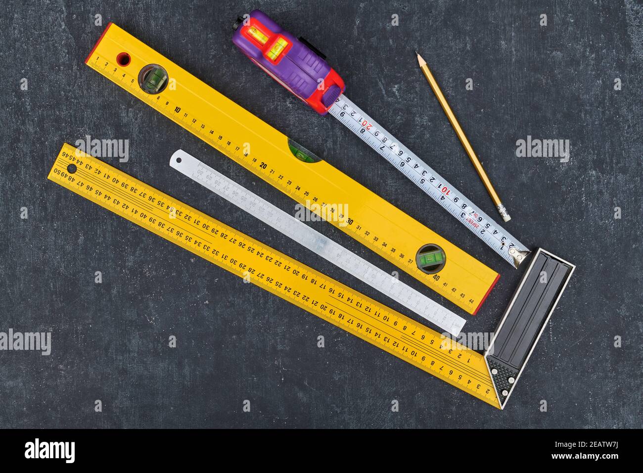Lineal, Maßband, Konstruktionsebene und Bleistift auf grauem Hintergrund, Nahaufnahme von oben Stockfoto
