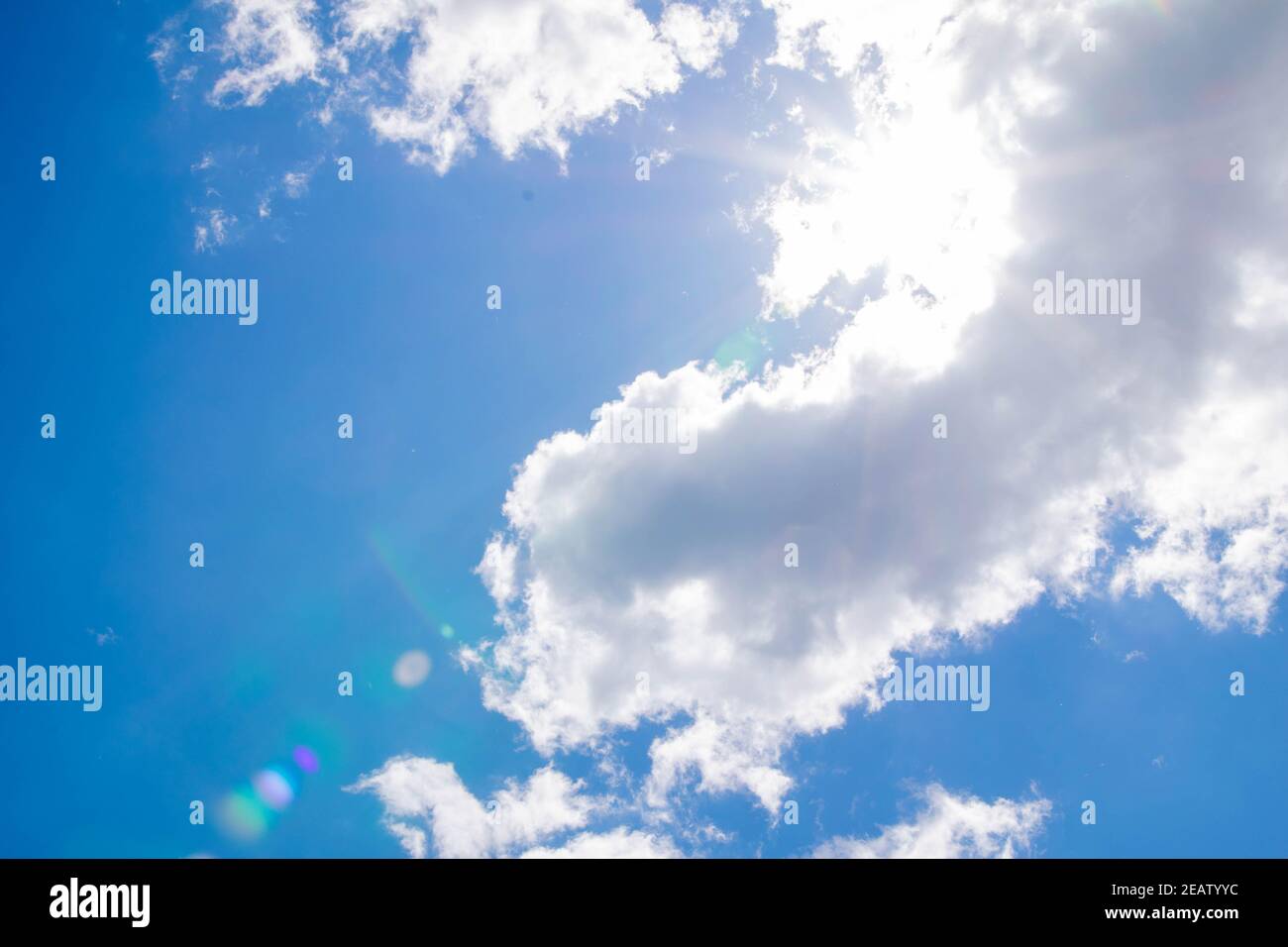 Cumulus Wolken am blauen Himmel und Sonnenstrahlen brechen durch die Wolken. Speicherplatz kopieren Stockfoto