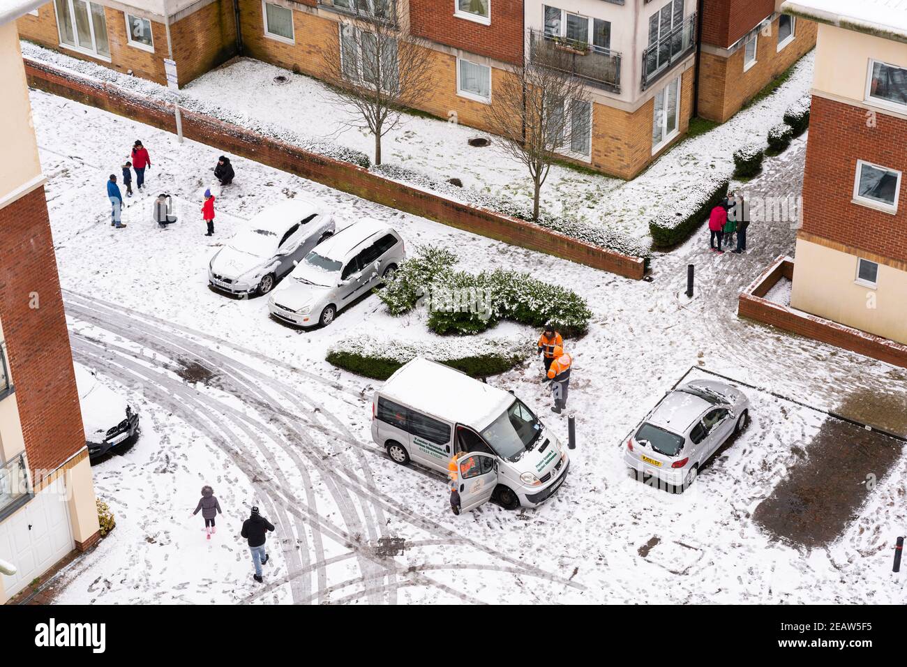 Eine Luftaufnahme von Menschen, die im Schnee draußen vor Winterthur Way Wohnungen in Basingstoke spazieren und spielen. Januar 2021. Hampshire, Großbritannien Stockfoto