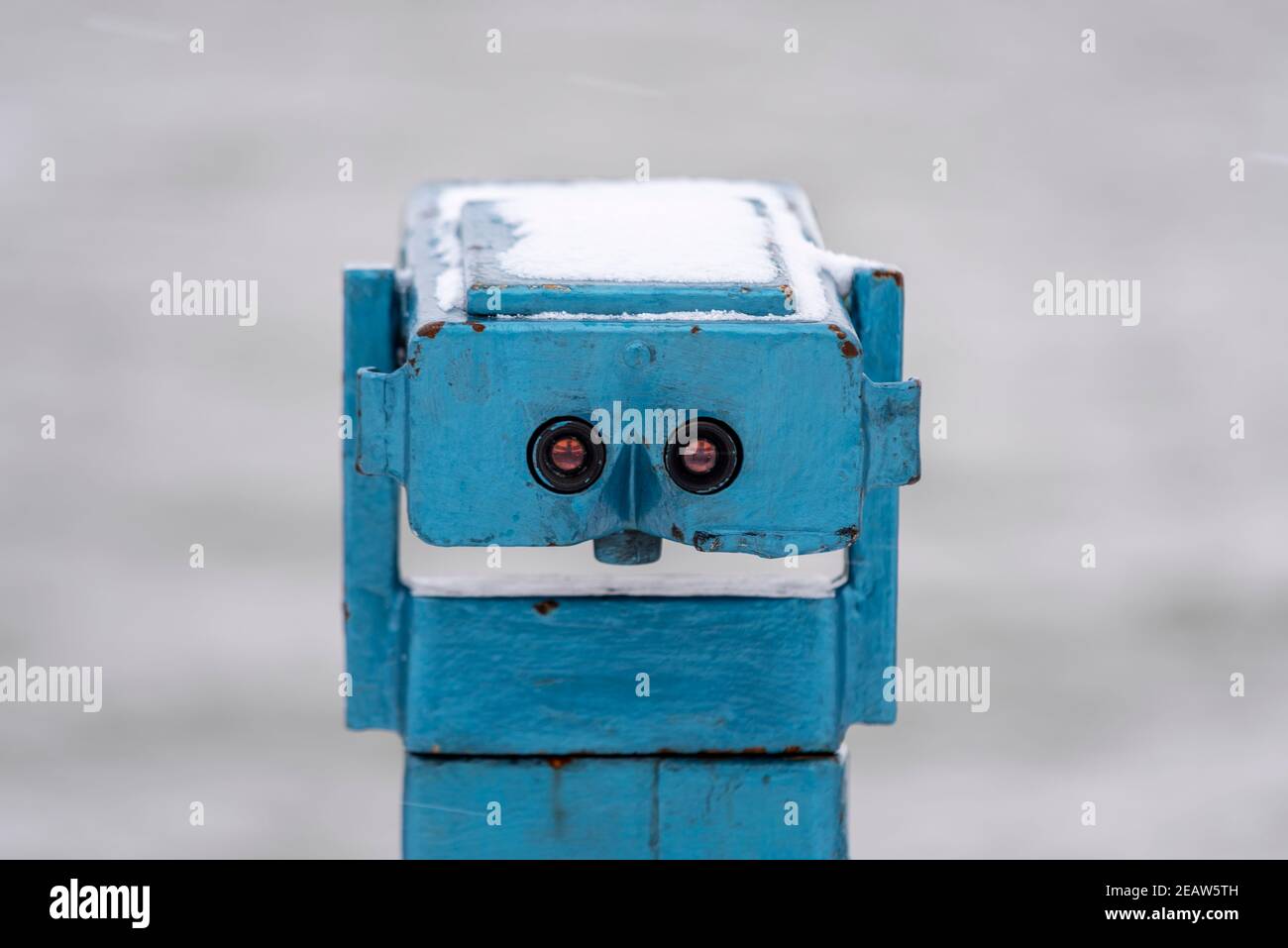 Altes Münzfernrohr an der Küste in Southend on Sea, Essex, Großbritannien, mit Schnee von Storm Darcy. Sieht aus wie ein Gesicht Stockfoto