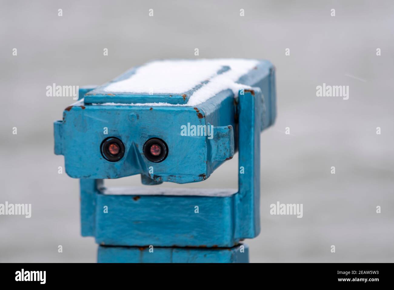 Altes Münzfernrohr an der Küste in Southend on Sea, Essex, Großbritannien, mit Schnee von Storm Darcy. Sieht aus wie ein Gesicht Stockfoto