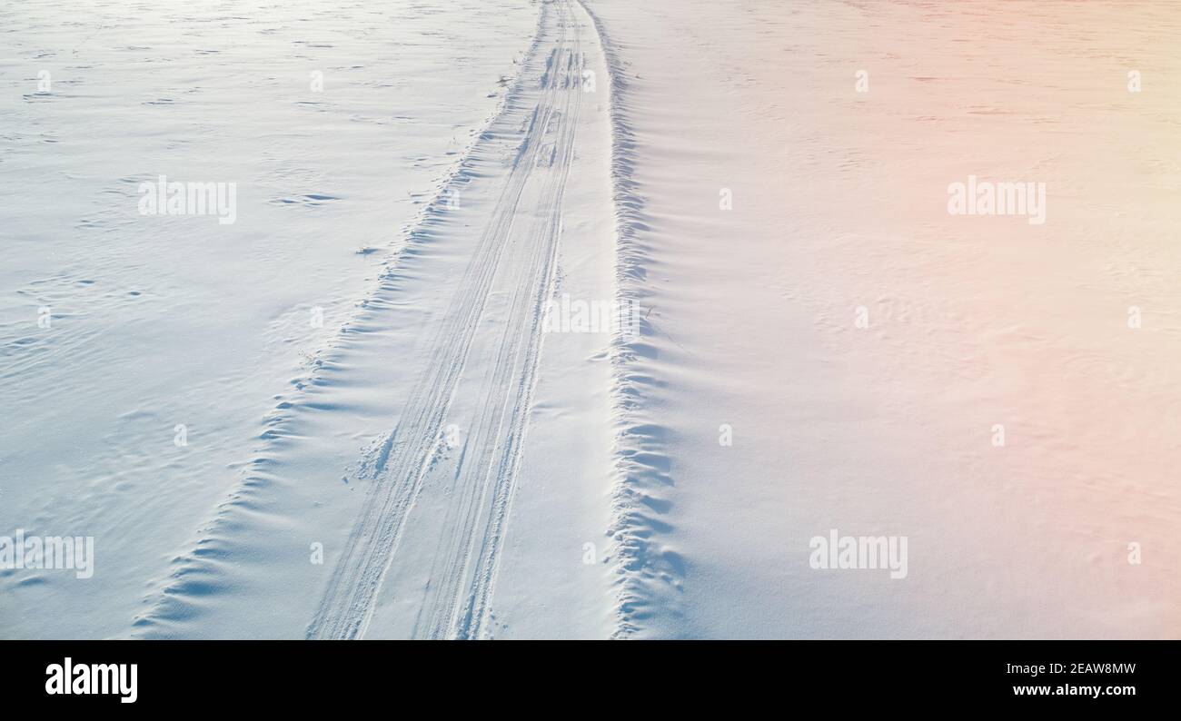 Auto Spuren auf Schneefeld Antenne über Drohne Ansicht Stockfoto