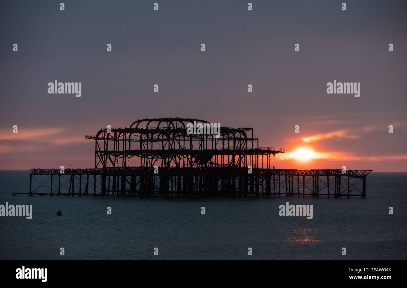 Die Sonne untergeht hinter dem West Pier in Brighton, Großbritannien, 6. Februar 2021 Stockfoto
