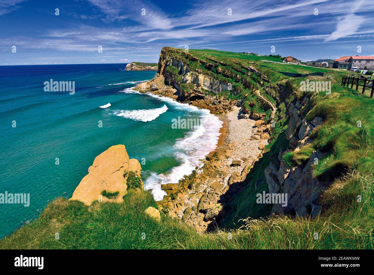 Toller Blick auf die Küste mit wildem Strand, grünem Meer und Klippen und blauem Himmel, Stockfoto