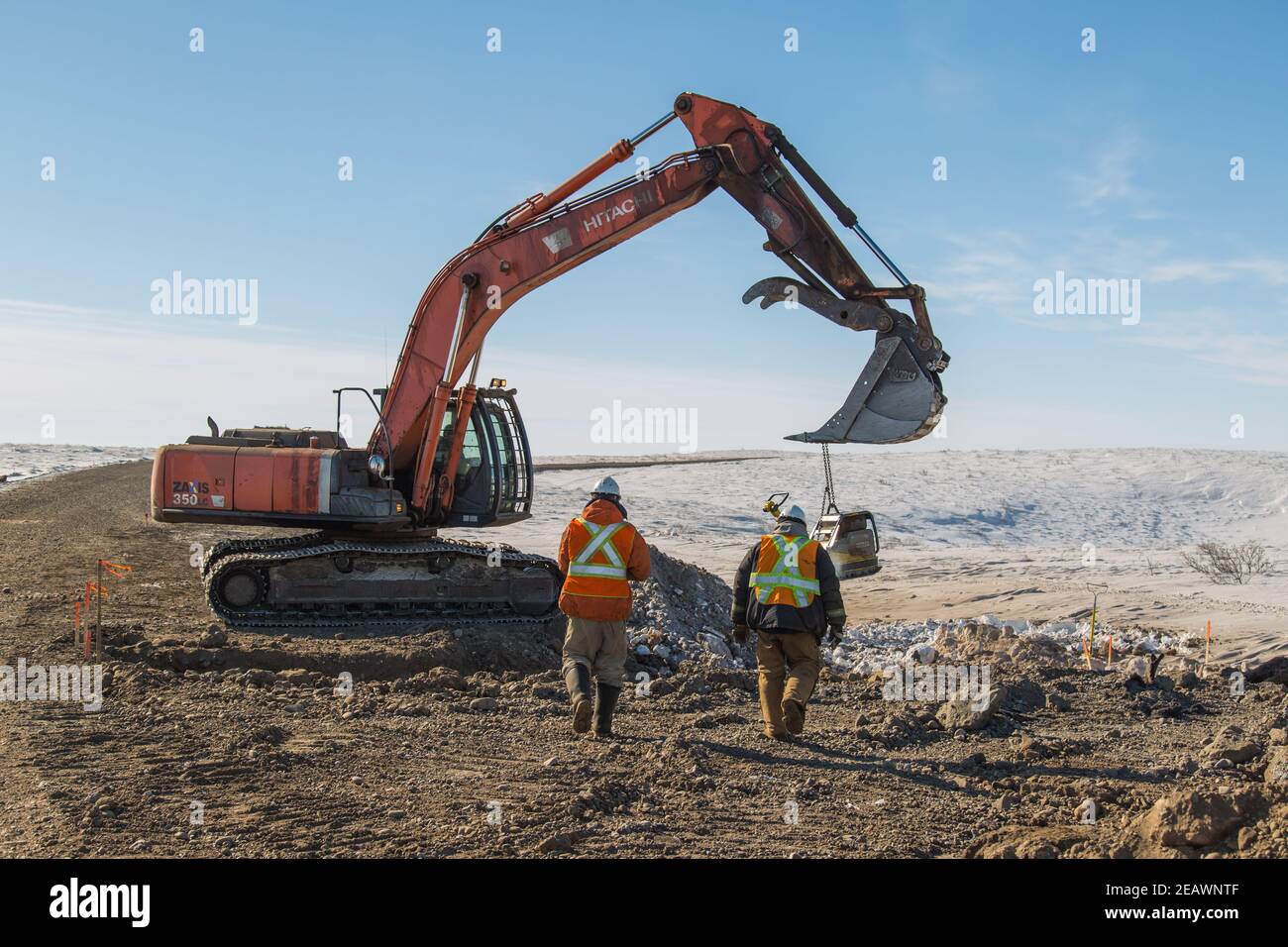 Männer und Bagger arbeiten am Bau des Allwetter-Kieses Inuvik-Tuktoyaktuk Highway im Winter, Northwest Territories, Kanadas Arktis. Stockfoto