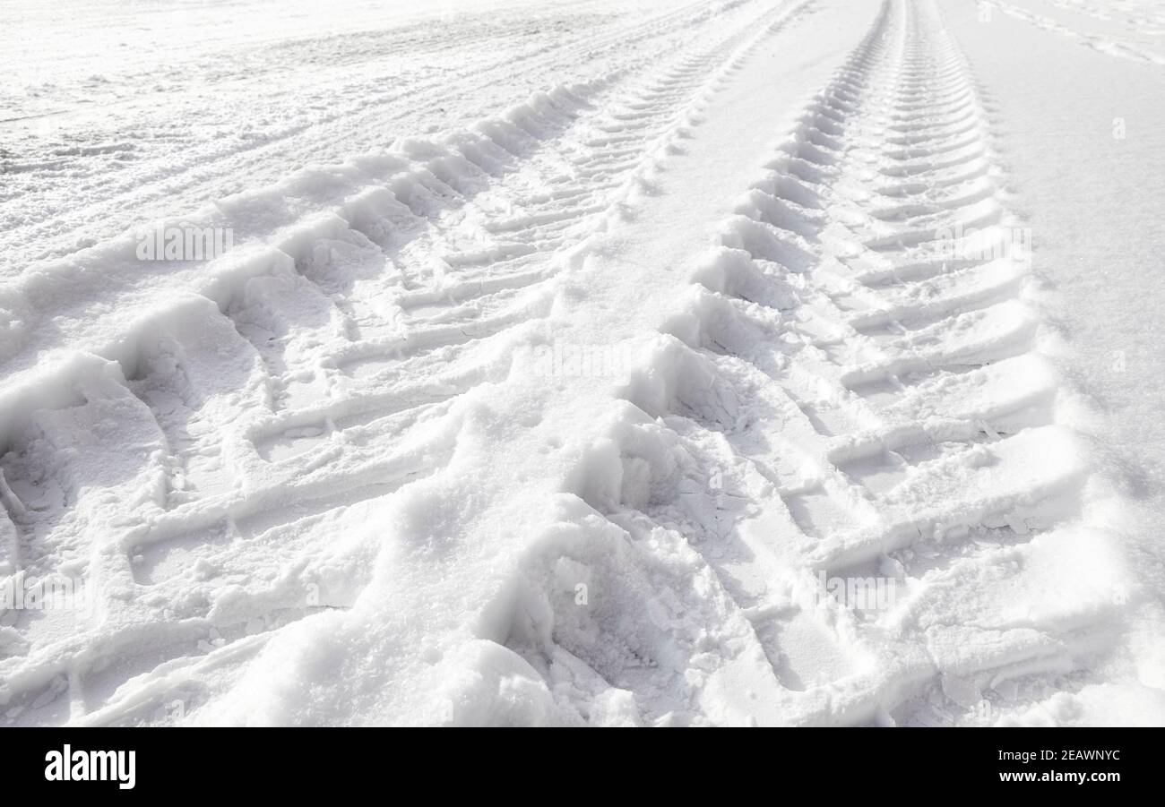 Abbildung der Reifenspuren von schweren Fahrzeugen im Schnee. Stockfoto