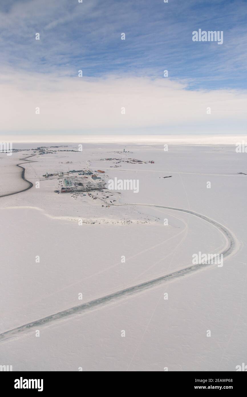 Luftaufnahme des Industriegebiets des arktischen Weilers Tuktoyaktuk im Winter umgeben von gefrorenem Arktischen Ozean, Nordwest-Territorien, Kanada. Stockfoto