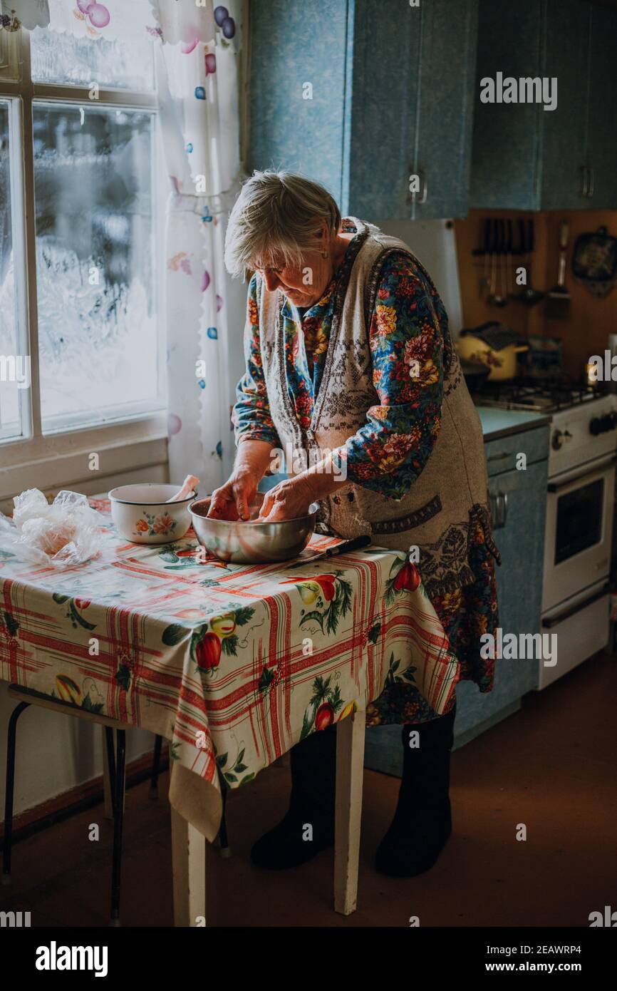 Russische Oma schlachtet mit bloßen Händen ein Huhn Stockfoto