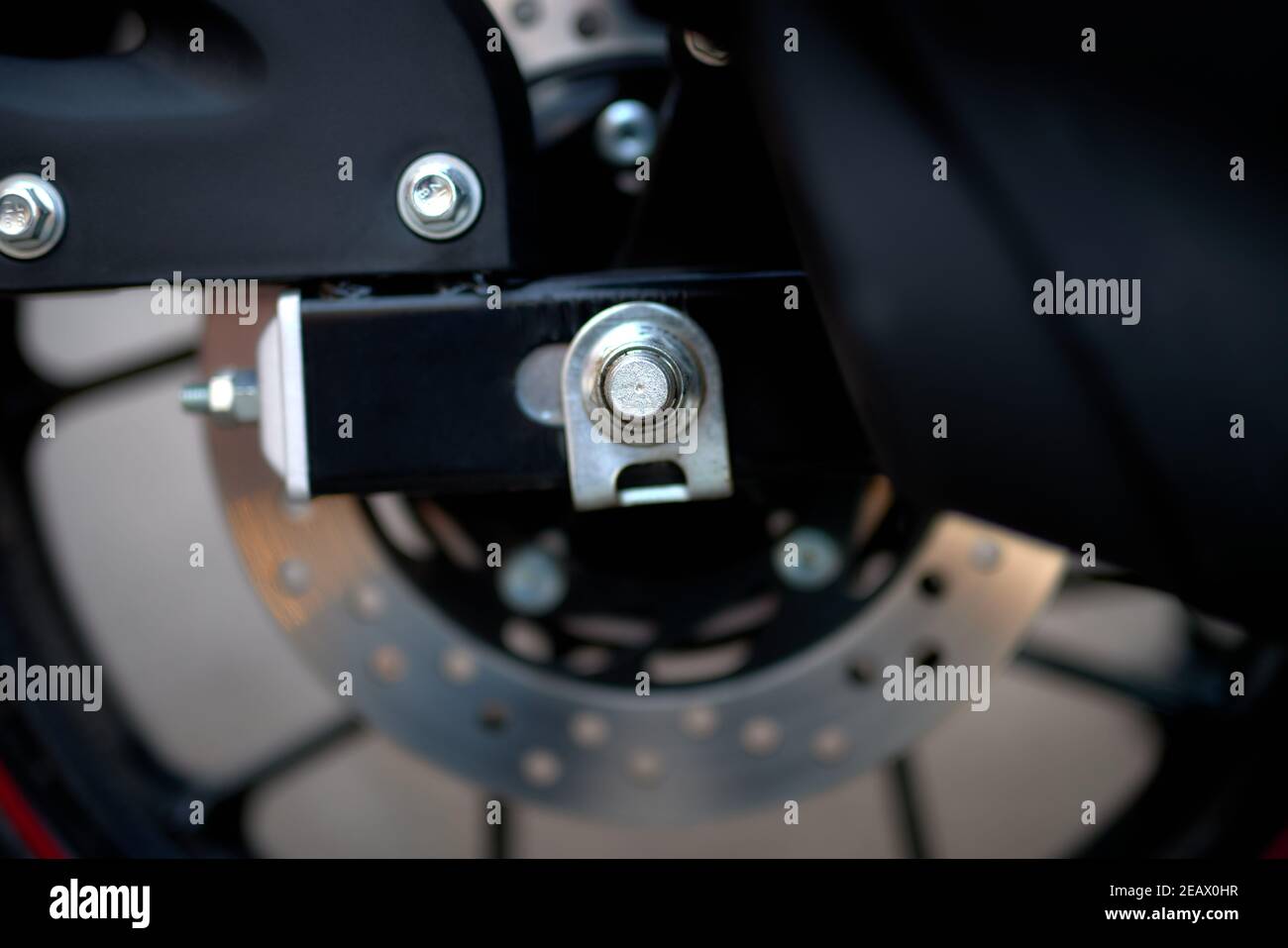 Detail von Achse, Rad und Hinterrad Scheibenbremse eines Motorrads Stockfoto