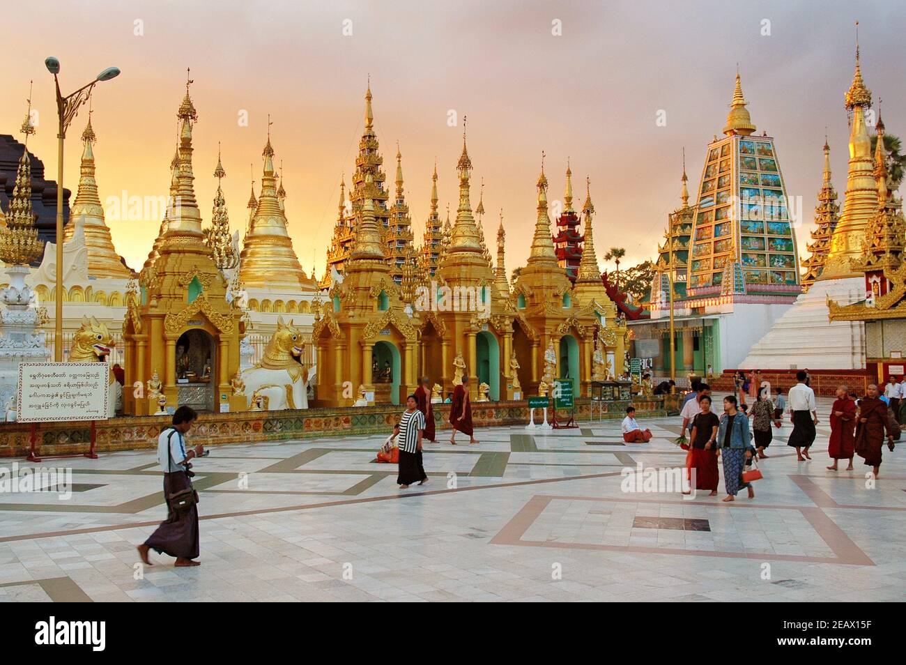 Besucher in der Shwedagon Pagode bei Sonnenuntergang in Yangon, Myanmar Stockfoto